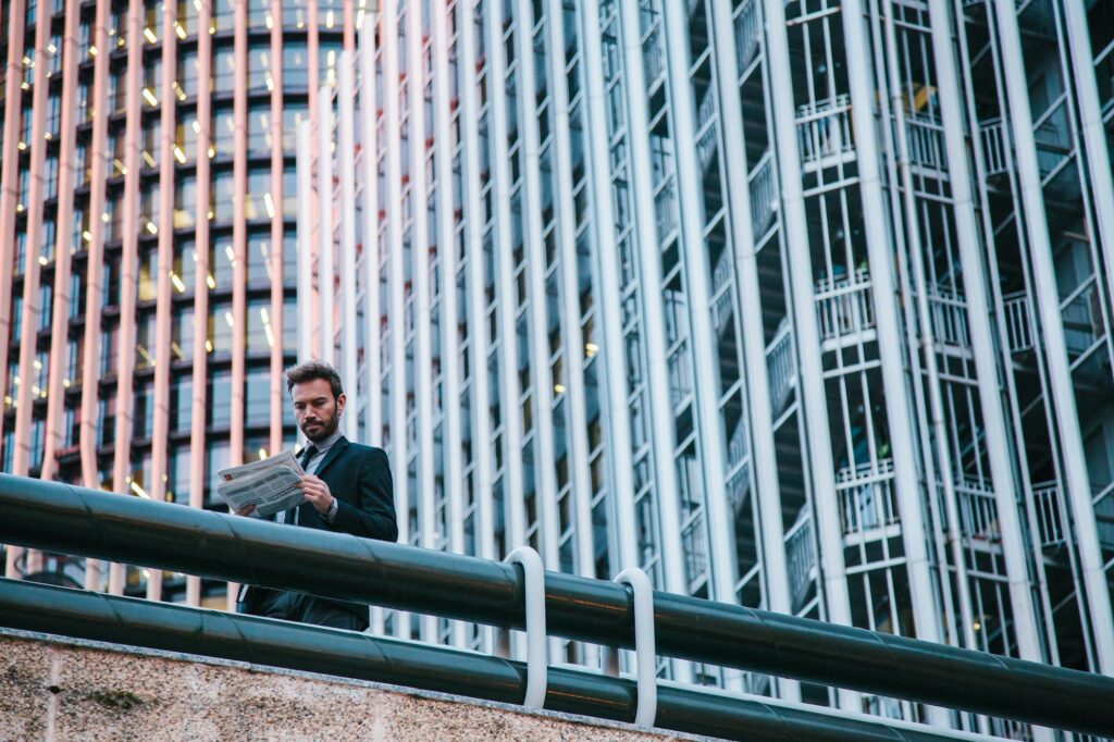 Businessman Holding a Newspaper in a Finance Area